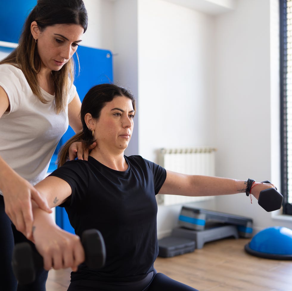 woman using weights for strength training during physical therapy session
