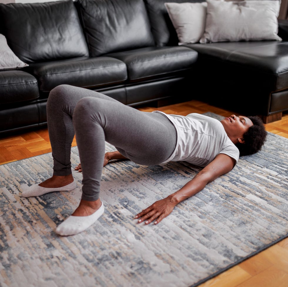 woman practicing yoga, glute bridge exercise, dvi pada pithasana pose