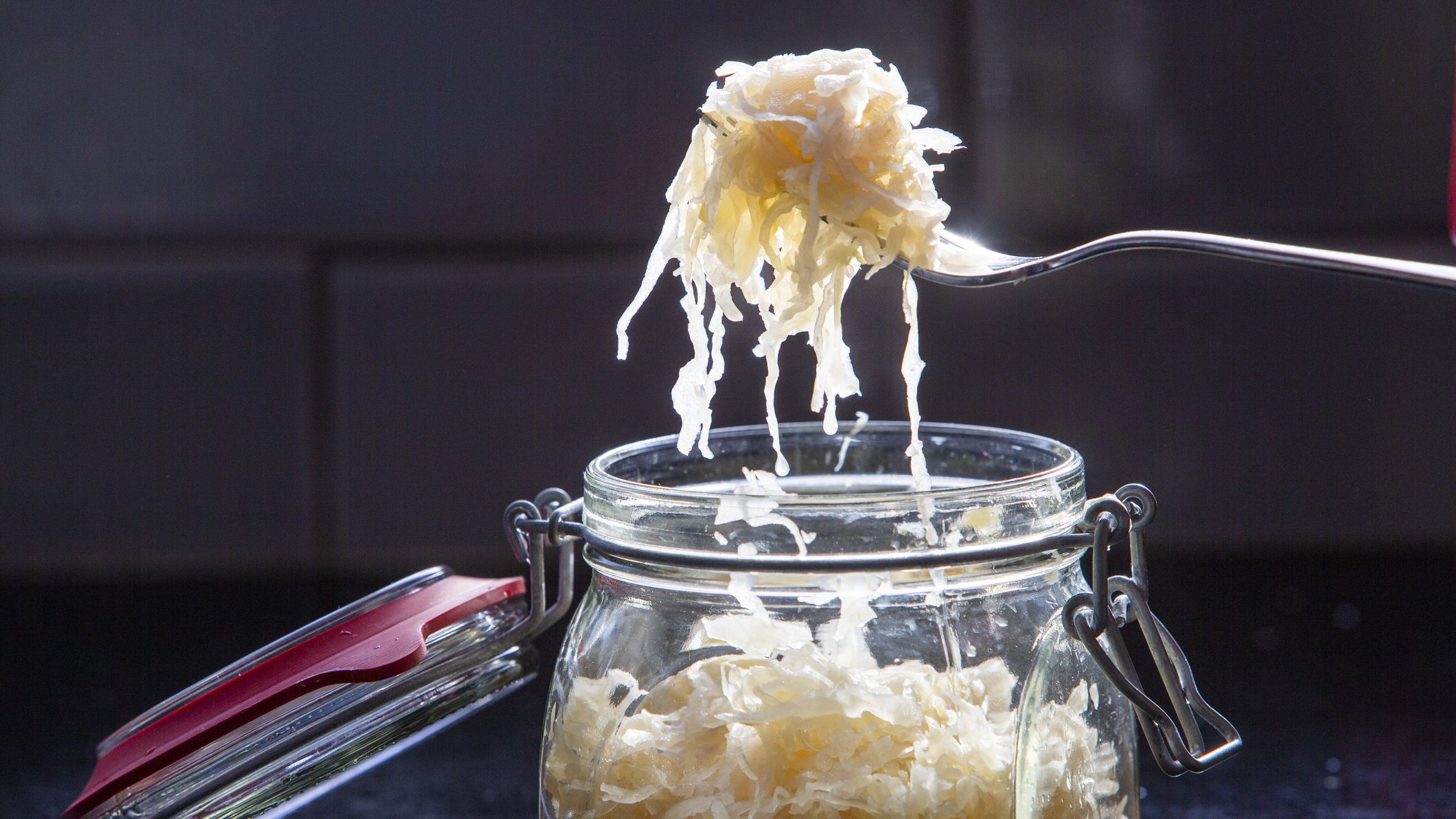 Fork-full of Sauerkraut over a glass jar