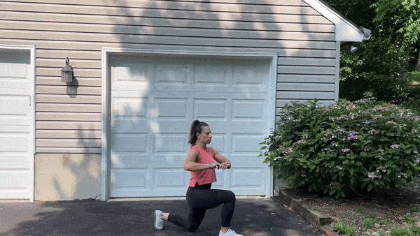 trainer doing lunge twists outside in front of garage