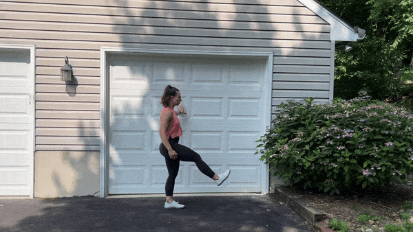 dynamic stretches leg swings trainer doing leg swings outside in front of garage