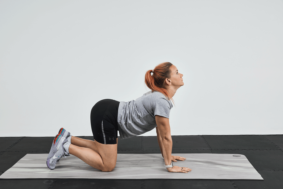 Woman performing a yoga pose on a mat, with her back arched and head tilted upward. Woman performing a yoga pose on a mat, with her back arched and head tilted upward.